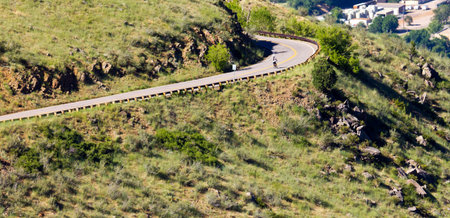 Riding a bicycle down a winding mountain roadの写真素材