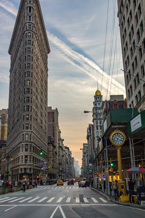NEW YORK CITY â CIRCA 2016: The Flatiron Building stands between Broadway and Fifth Avenue on a busy Saturday evening in Manhattan, New York City. The Flatiron Building is a 22 story triangular shaped building built in 1902.のeditorial素材