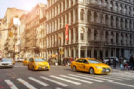 Taxis driving through intersection on Broadway with crowds of people shopping in the Soho neighborhood of New York Cityの写真素材