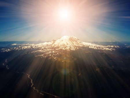 Heavenly rays of sunlight above mountain peakの写真素材