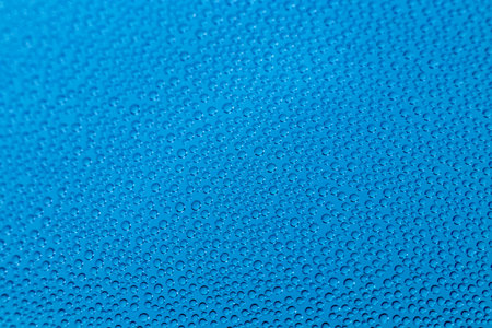 Wet water drops closeup pattern on blue backgroundの写真素材