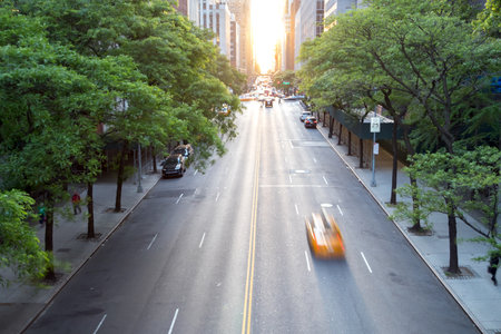 New York City taxi speeding down 42nd Street in Midtown Manhattan with the sunset in the backgroundの写真素材