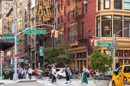 NEW YORK CITY - JULY, 2018: People and cars cross a busy intersection on Broadway along Union Square...