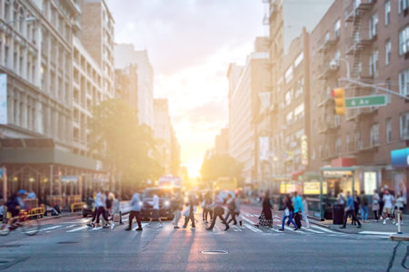 Diverse crowd of people walking across the busy intersection of 23rd Street and 6th Avenue in...