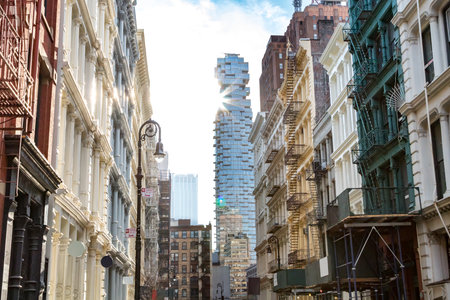 Sunlight shines on the buildings along Greene Street with a view towards the intersection on Canal Street in SOHO Manhattan, New York Cityのeditorial素材