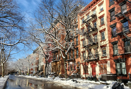 Snowy winter scene with the colorful buildings along 10th Street in the East Village of New York City NYCのeditorial素材