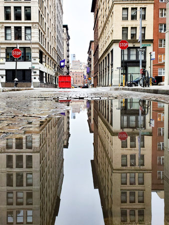 Buildings reflected in a puddle on Green Street in New York City NYCのeditorial素材