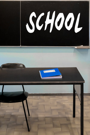 school classroom with a blackboard hanging on the wall and the register of votes on the deskの写真素材