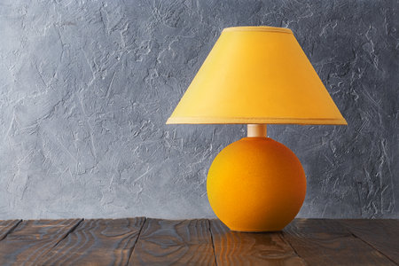concept of home comfort. Yellow lamp on wall backgroundの写真素材