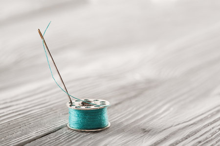 iron coil with blue thread on a white wooden backgroundの写真素材