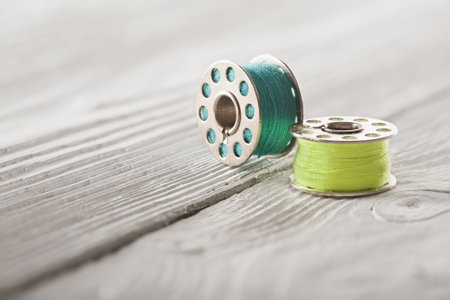 iron coil with blue and yellow thread on a wooden background