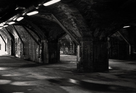 Going through an old railway viaduct to the outside taken in black and whiteの写真素材