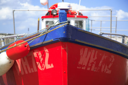 Red fishing boat moored up on Staithes beachの写真素材