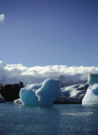 Icebergs against a blue sky and fluffy white clouds