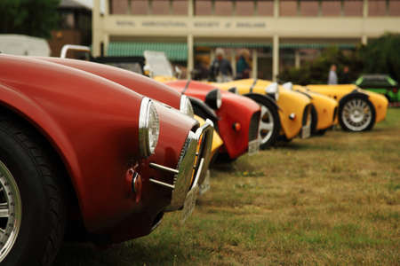 Red and yellow sports cars lined up at a car show in the UKの写真素材