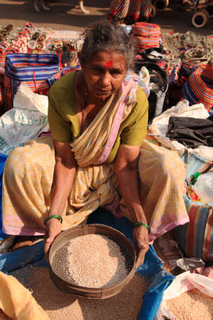 Woman sifting wheat in a street market, Goa, India 25 January 2008のeditorial素材