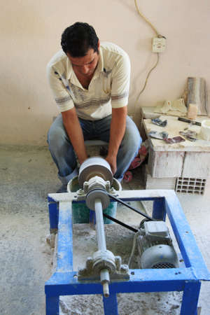 Worker sat on the floor using a lathe in Turkey 27 June 2008のeditorial素材