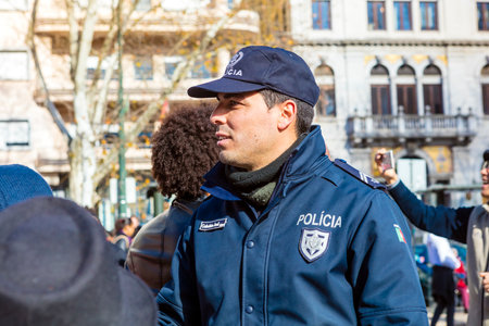 LISBON , PORTUGAL - FEBRUARY 10, 2018:  Unidentified Portuguese policeman in a crowd at the Avenida da Liberdade during carnival procession.のeditorial素材