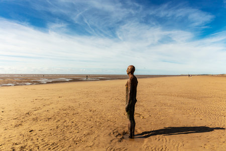 Deserted beach at Crosby near Liverpool with cast iron sculptures 'Another Place' by Antony Gormley.のeditorial素材