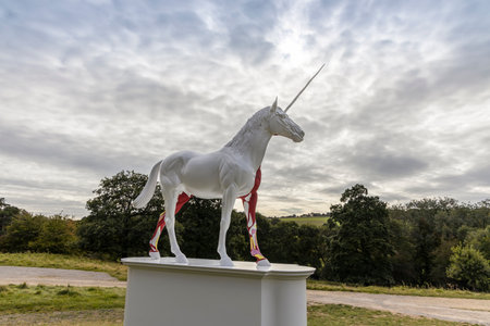 WAKEFIELD, YORKSHIRE, UK - September 18, 2019: Damien Hirst sculpture Myth is of white unicorn with half of its skin flayed  revealing vibrant red, pink and yellow musculature and tissues.のeditorial素材