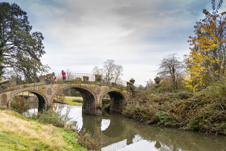 Old bridge in scenic surroundings at the Yorkshire Sculpture Park near Wakefield, UK.のeditorial素材
