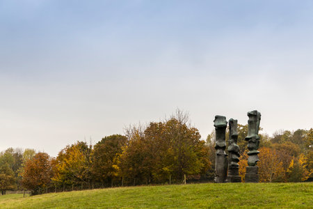 WAKEFIELD, YORKSHIRE, UK - November 6, 2019:  Landscape with Upright Motives No. 1 (Glenkiln Cross): No 2; No 7 bronze sculpture by Henry Moore in Yorkshire Sculpture Park.のeditorial素材