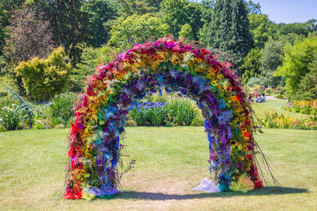 Rainbow arch creative decorative composition of multicoloured flowers in a park.の写真素材