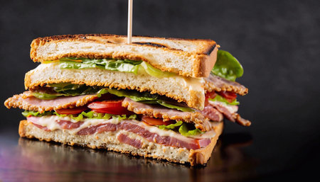 Tuna egg salad sandwich with green olives and black salt on the side on white wooden table against gray backgroundの写真素材
