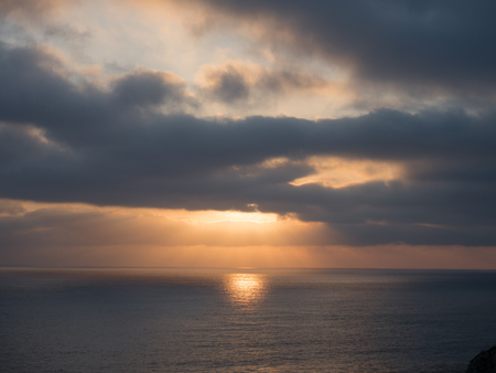 Beams of sunlight showing through a cloudy sunsetの写真素材