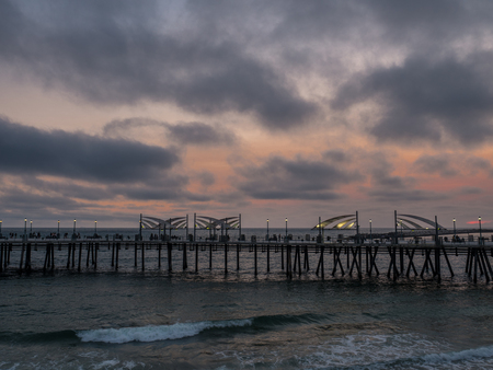 Red sunset behind pier on a cloudy nightの写真素材