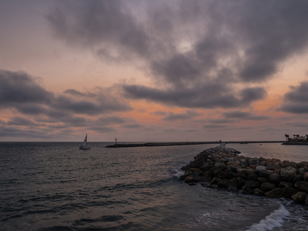 Red sky with sunset behind breakwaterの写真素材