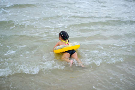 The children colorful swimming suit playing in the seaの写真素材