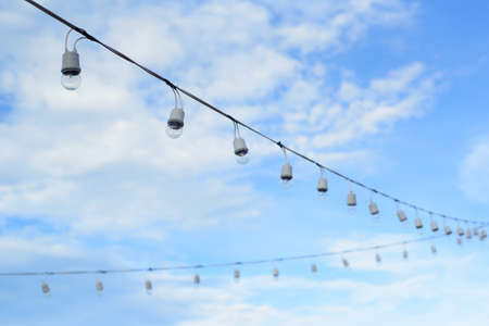 The line of light bulbs in blue sky background.の写真素材