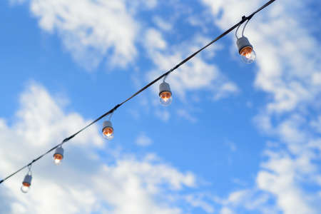 The line of light bulbs in blue sky background.の写真素材