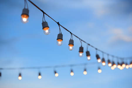 The line of light bulbs in blue sky background.の写真素材