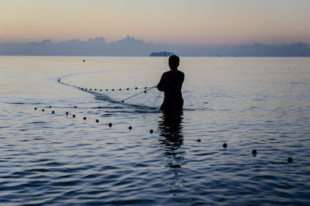 Silhouette fisherman in the morning, Thailandの写真素材