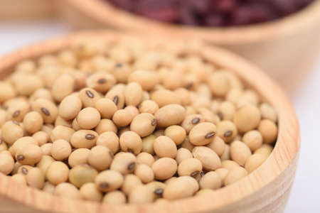 The beans are in a wooden bowl on a white background.の写真素材