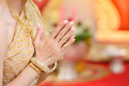 The bride's hand wears a ring on the bridal gown.の写真素材