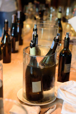Many wine bottles are immersed in an ice bucket. Ready for the celebration for this dinner.の写真素材