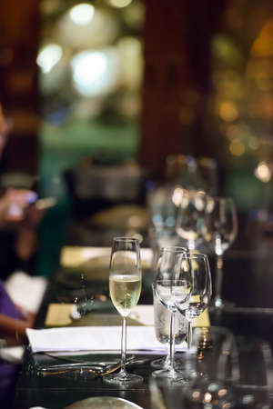 A glass of wine is placed on the dinner table. Ready to serve the people tonight.の写真素材