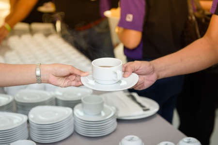Staff Presenting hot coffee to customers. At break time of the meeting.の写真素材