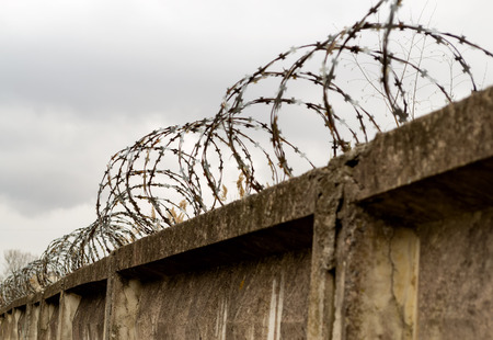 barbed wire fence and stone wallの写真素材