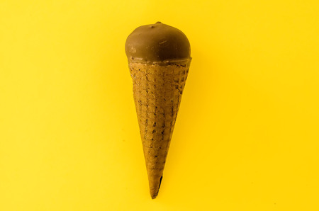 Vanilla ice cream with cranberry jam in a sugar cone dipped in chocolate