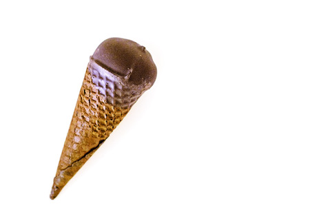 Vanilla ice cream with cranberry jam in a sugar cone dipped in chocolate on white isolated...