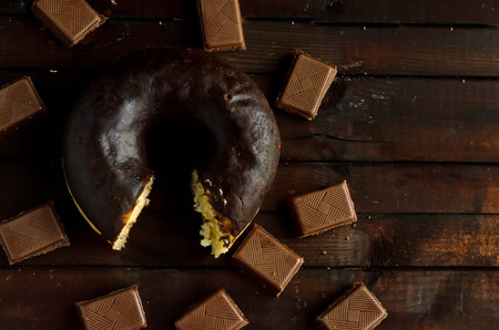 Bitten chocolate donut with coffee and milk chocolate.