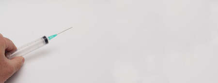Man holds empty disposable syringe on white background.の写真素材