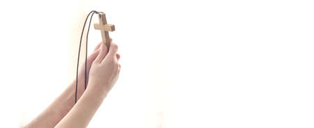 Outstretched hands with a cross to God in the light.の写真素材