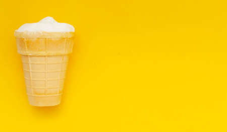 Waffle cup of cream ice cream on pastel yellow background,copyspace.の写真素材