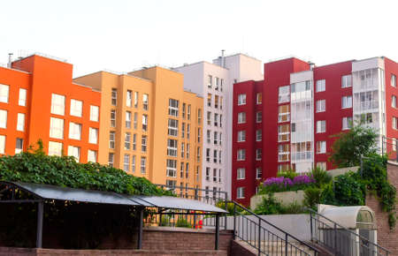 Modern multi-colored apartment building with playground and garden.の写真素材