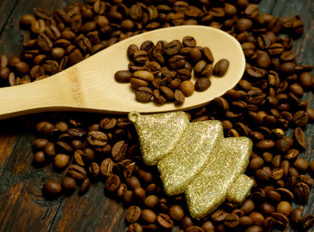 Close up, wooden spoon with coffee beans and christmas tree toy.の写真素材